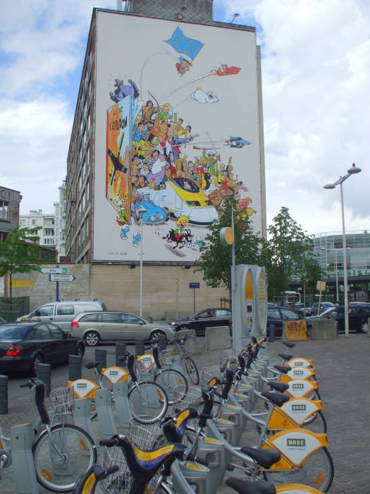 Comic book mural and a bicycle rental point just outside the Brussels Midi train station.