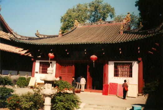 White and red Buddhist temple with sweeping roof.