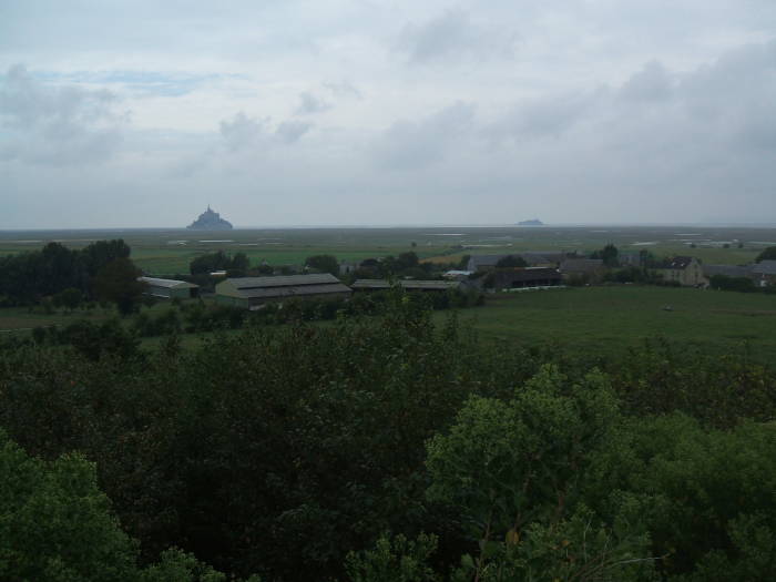 The fortress of Mont Saint-Michel on the far horizon above the tidal flats.