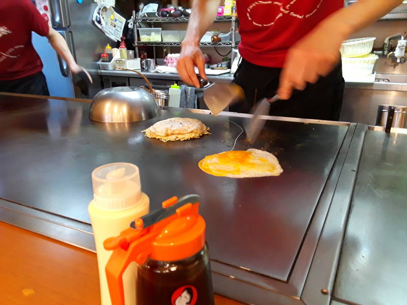 Okonomiyaki chef in Hiroshima, batter and egg.