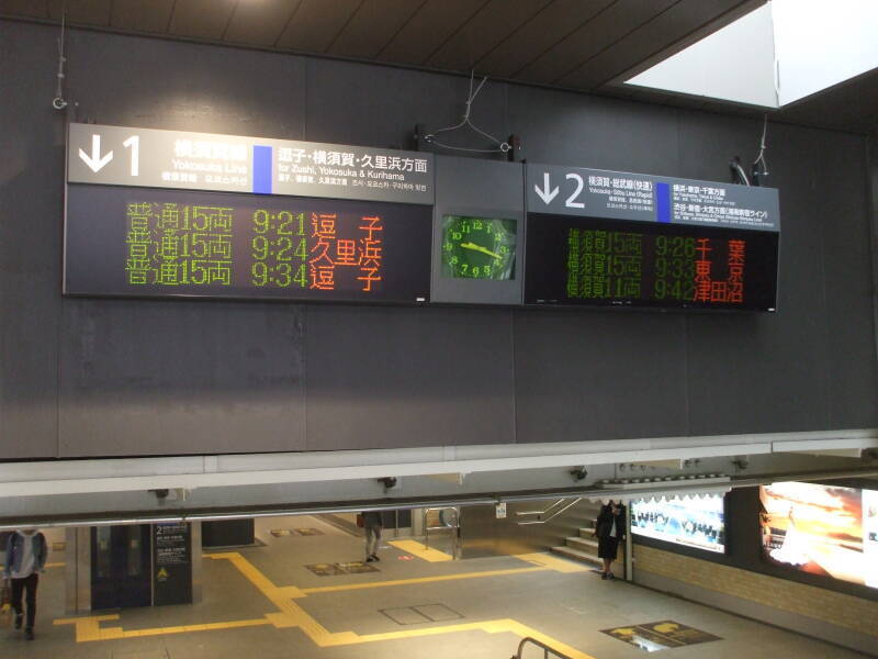 Sign announcing trains in Japanese in train station in Kamakura, Japan.
