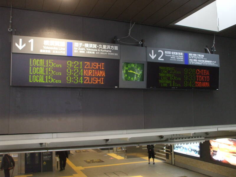 Sign announcing trains in rōmaji in train station in Kamakura, Japan.