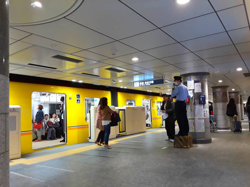 Uniformed platform attendant in a Tōkyō subway station.