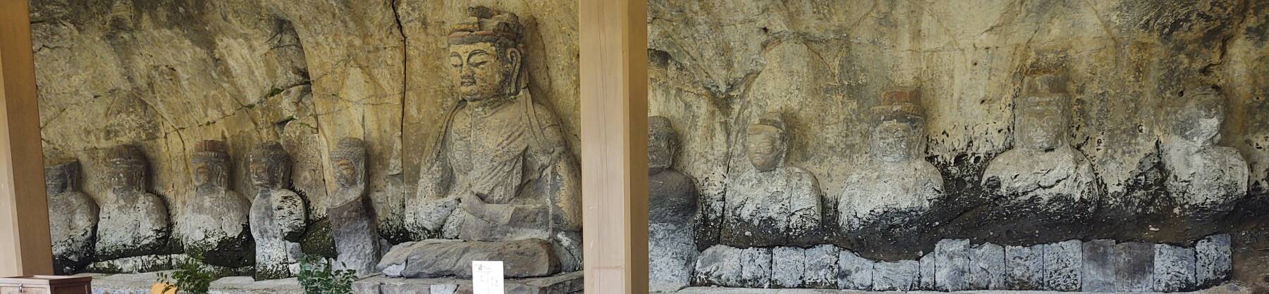 Group of Buddhas carved into a tuff cliff face.
