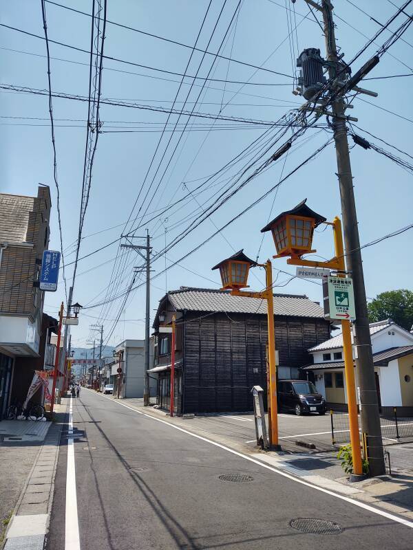 Traditional business street in Usuki, with old-style lanterns and modern power lines.