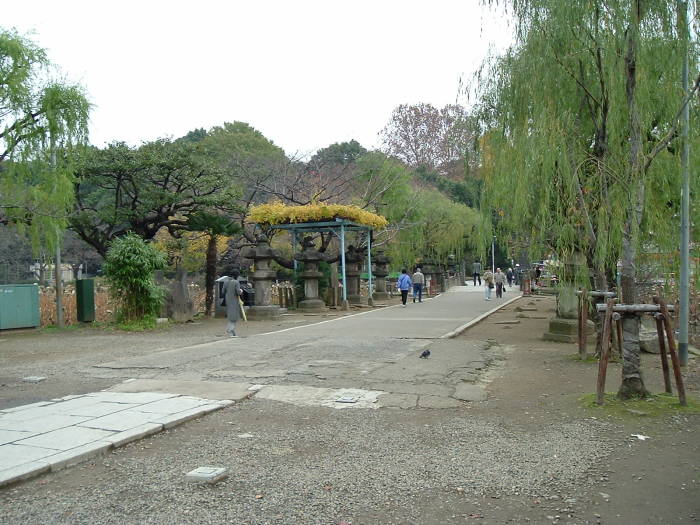 Stone lanterns and statues along the causeway leading to the Benzaiten Buddhist Temple in Tōkyō, Japan.