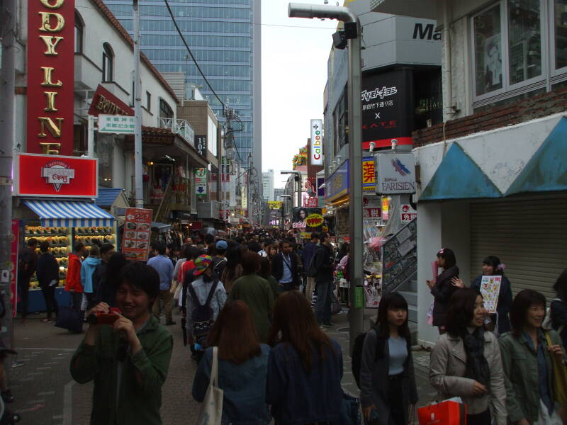 People pass crowded colorful shops on Takeshita-dori or Takeshita Street in Harajuku.