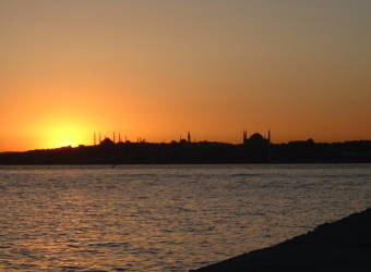View across the Bosphorus in Istanbul to the Sultanahmet district: Sunset behind the Blue Mosque and the Aya Sofya or Haghia Sophia.