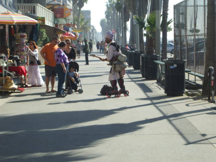 Harry Perry plays his electric guitar on roller skates on the boardwalk in Venice, California.