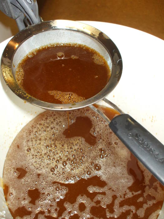 Beer brewing: putting the wort in the fermenter, filtering out the trub.