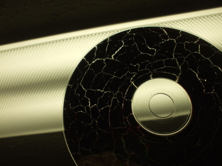 CD/DVD destroyed in a microwave, silhouetted against a light.