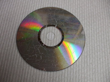 CD/DVD destroyed in a microwave, lying on a paper towel.