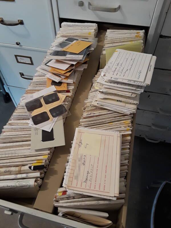 Three cabinets filled with dental records, a mix of cardstock, paper, x-ray film, and plastic film sleeves.