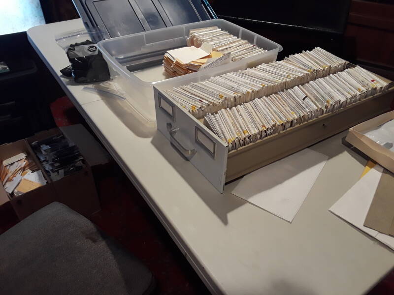 A drawer of dental records, a mix of cardstock, paper, x-ray film, and plastic film sleeves.