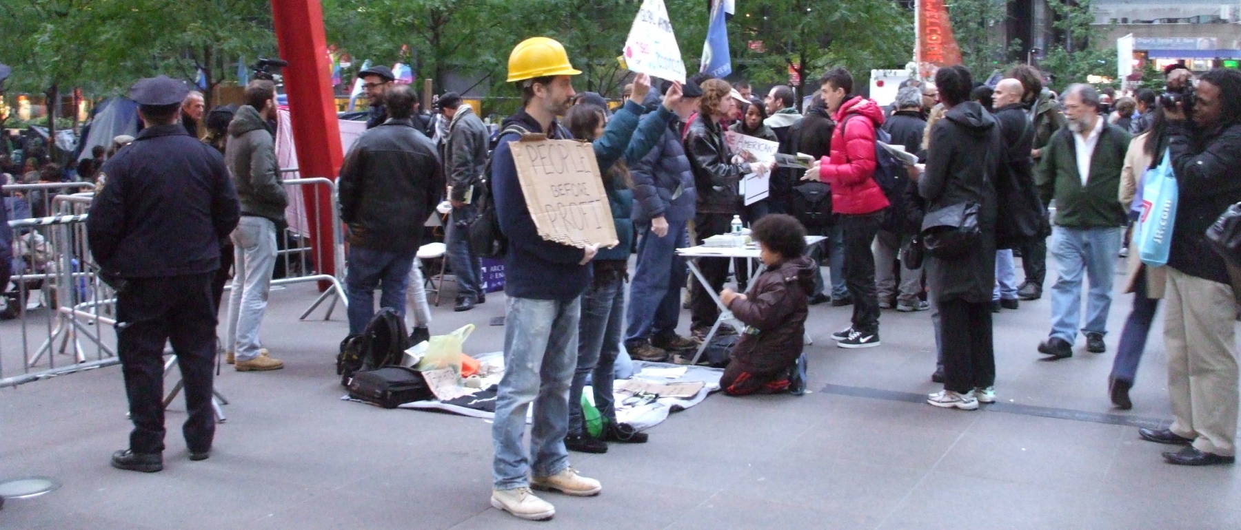 Occupy Wall Street protesters: man in hard hat with 'People Before Profit' sign.