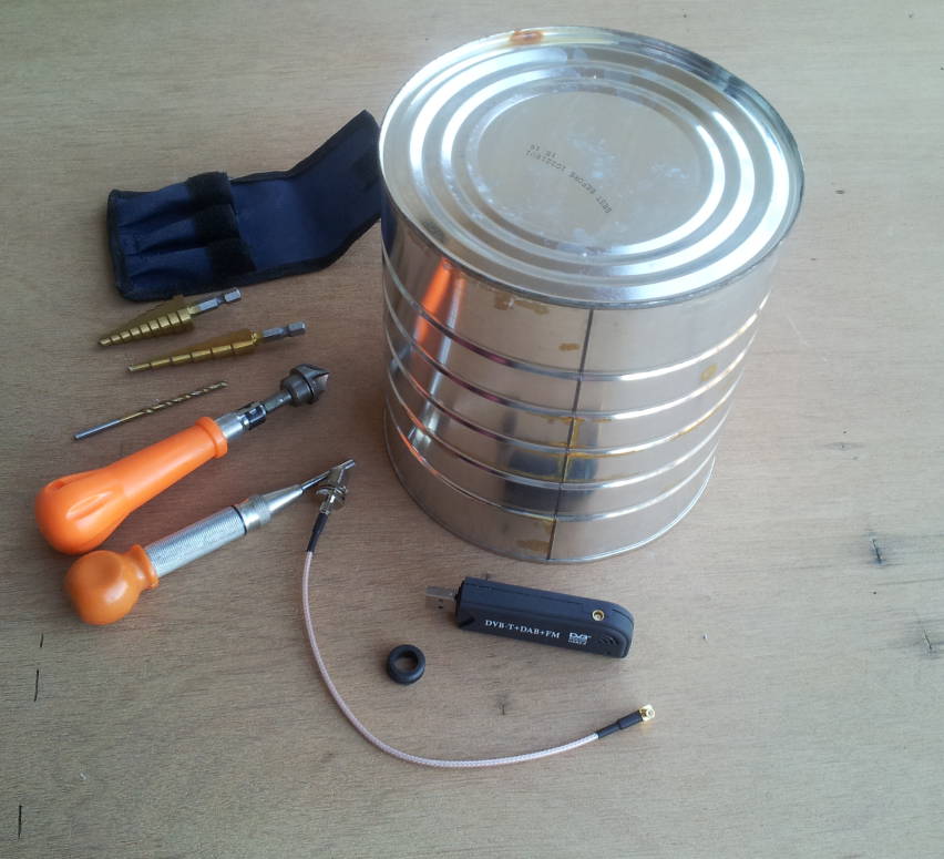 Parts and tools needed to build an ADS-B 1090 MHz antenna: large coffee can, RTL-SDR unit, female F to male right-angle MCX cable, rubber grommet, and tools.