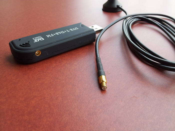 Close view of RTL SDR software-defined radio stick showing MCX connector and antenna cable.