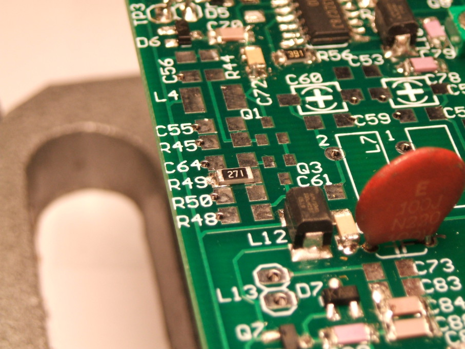 Size 1206 surface-mount resistor being soldered in place on a circuit board.
