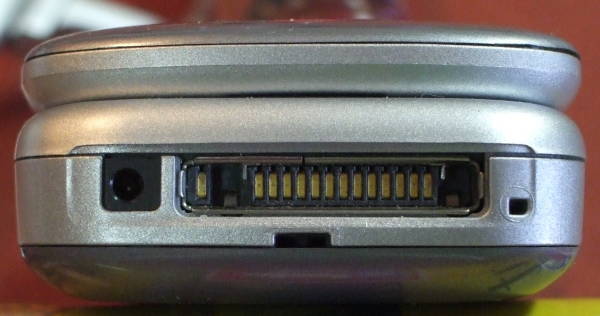 Nokia 6086 GSM phone Pop-Port connector, close-up on phone.  Small coaxial power connector at left, Pop-Port connector at right with data, control, and audio lines.