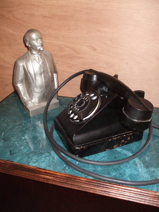 Soviet Багта-50 rotary telephone purchased at a flea market in Tallinn, Estonia, now adapted to mobile service.  At rear, an aluminum statue of Vladimir Lenin.