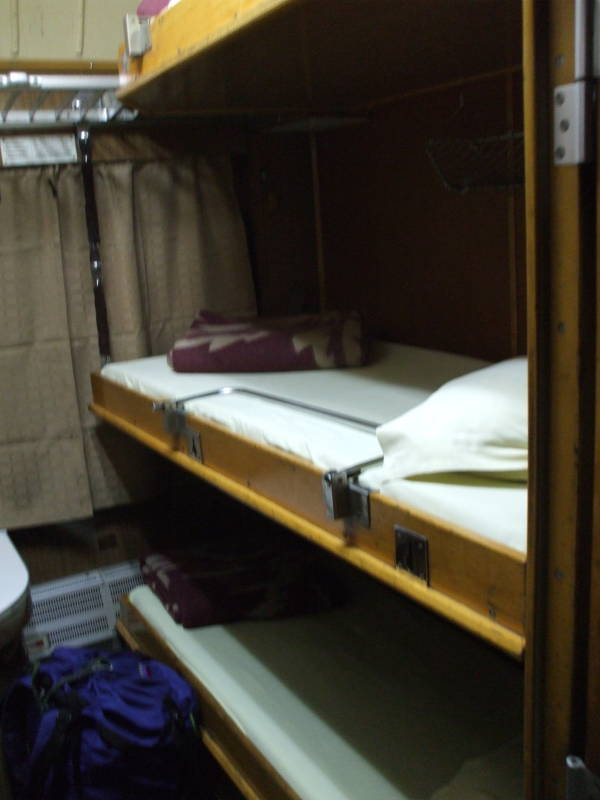 Three bunks or berths inside a Bulgarian sleeper or pullman passenger car.