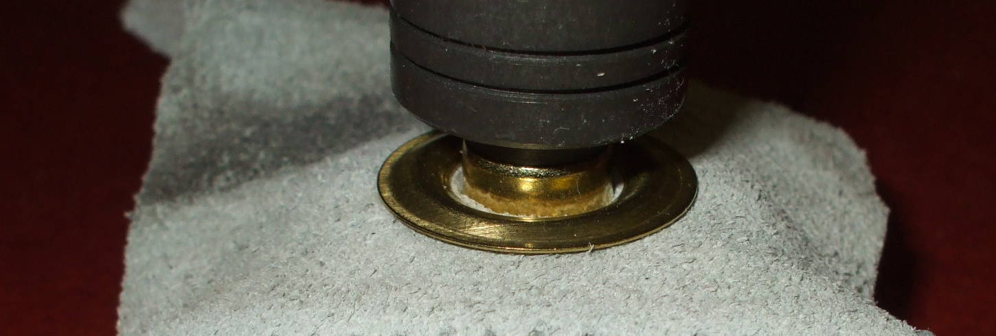 Brass grommet is prepared for shaping.
