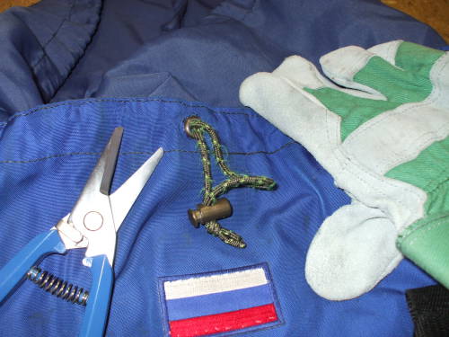 Shop shears and leather glove lying on a backpack.