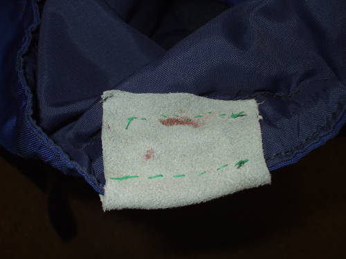 Dental floss stitching on leather repair piece on backpack.