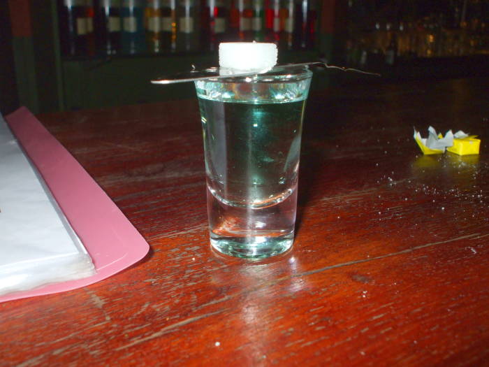 A glass of absinthe with a sugar cube and slotted spoon in the Delirium Tremens absinthe bar in Brussels.