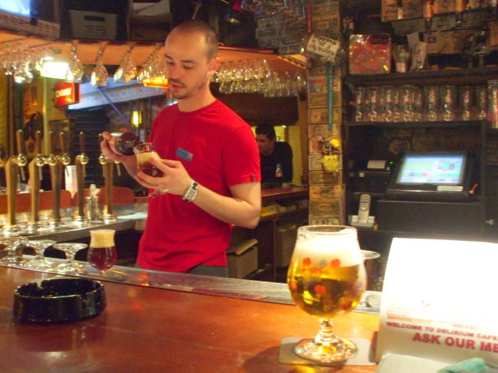 The bartender pouring Trappist beer into a special class in the Delirium Tremens cafe in Brussels.