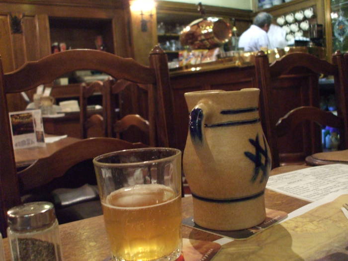 A small stoneware pichet of lambic biere blanc in À la Bécasse cafe in Brussels.