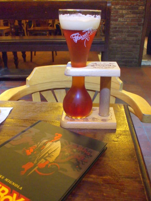 Kwak beer in its specialized glassware and a Hellboy graphic novel, in the Toone cafe connected to Royal Theatre Toone in Brussels.