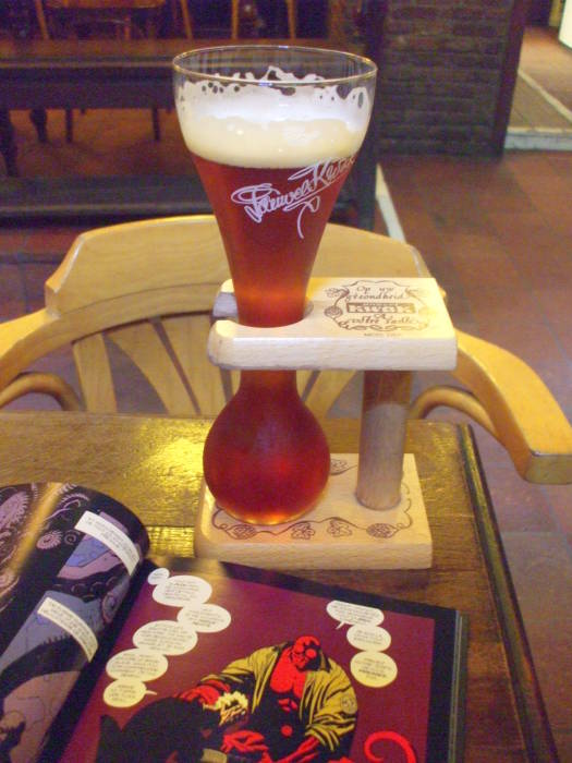 Kwak beer in its specialized glassware and a Hellboy graphic novel, in the Toone cafe connected to Royal Theatre Toone in Brussels.