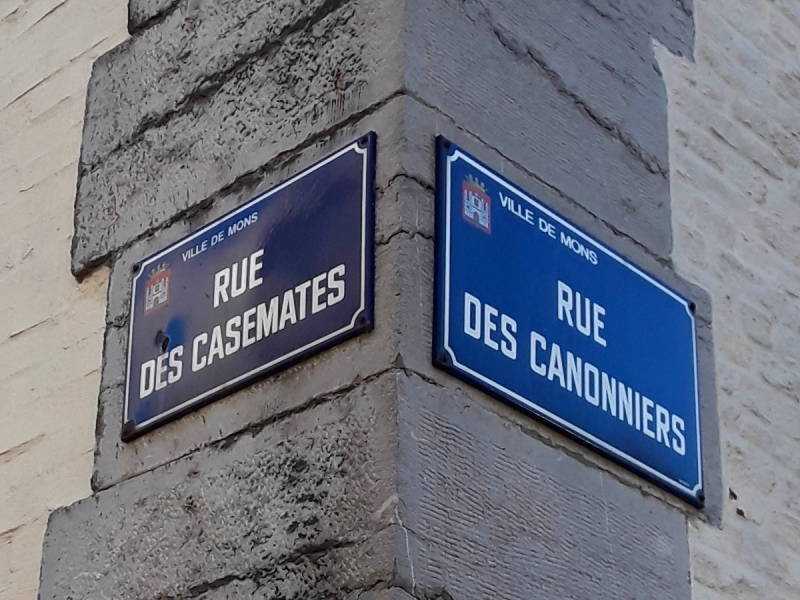 Street signs on casemates in Mons, Rue des Casemates at left, Rue des Canonniers at right