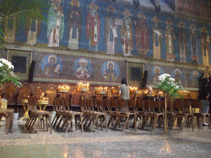 Interior of Sveti Nedelya Cathedral in Sofia, Bulgaria. Wall of fresco icons and many candles.