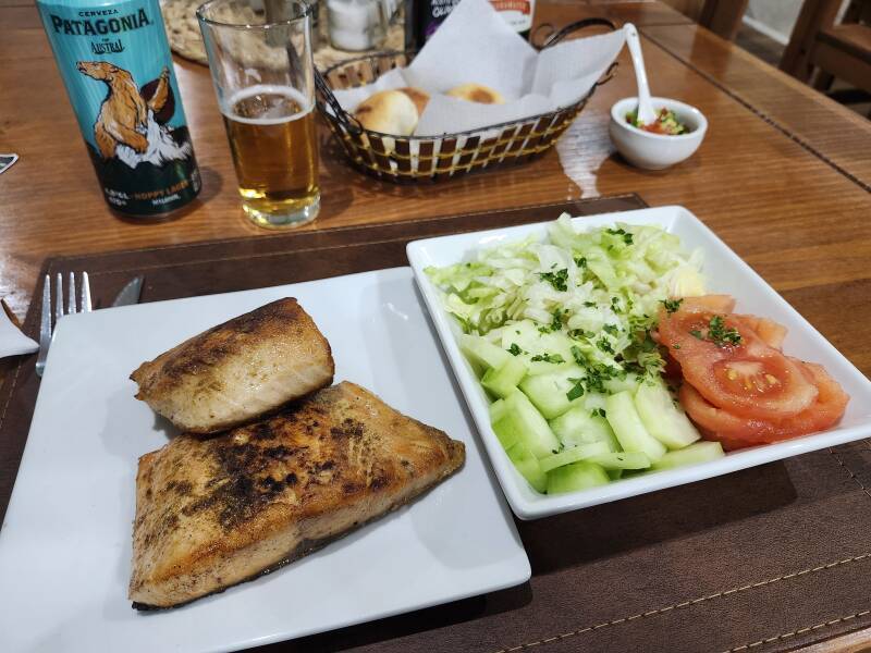 Patagonia Austral hoppy lager beer, salmon, salad, bread rolls, and pebre.