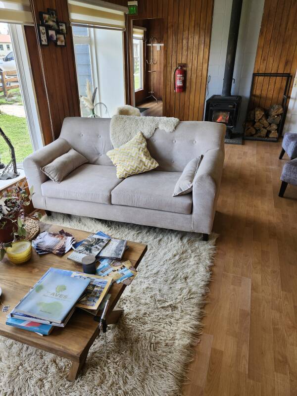 Shared room with couches, chairs, and wood stove.