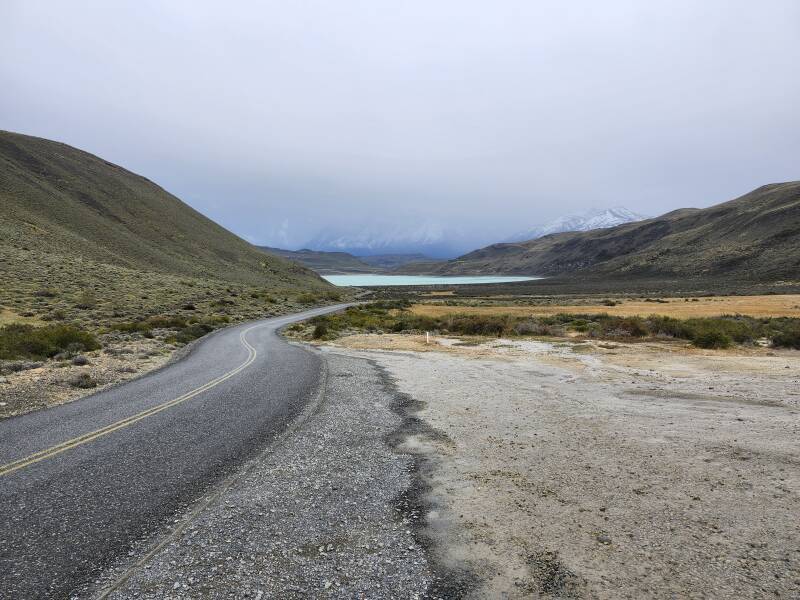 Approaching the park entrance, Laguna Amarga directly ahead, the mountains mostly invisible in low clouds.