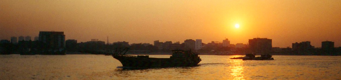 Sunset over small boats on the Pearl River in Guangzhou, China.