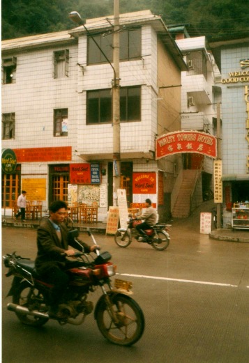 Two motorcycles pass the Fawlty Towers Hotel in Yangshuo, China.