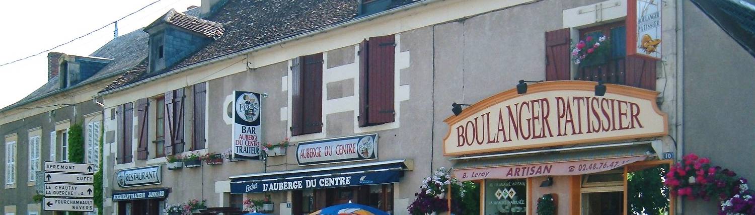Road signs and signs on local businesss in Cours-les-Barres, France.