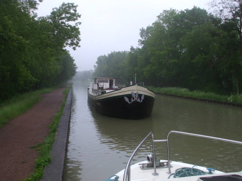Large commercial barge entering the high canal bridge at Guétin.