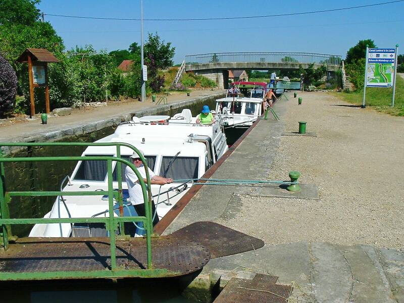Two boats passing through a lock in Maimbray, France.