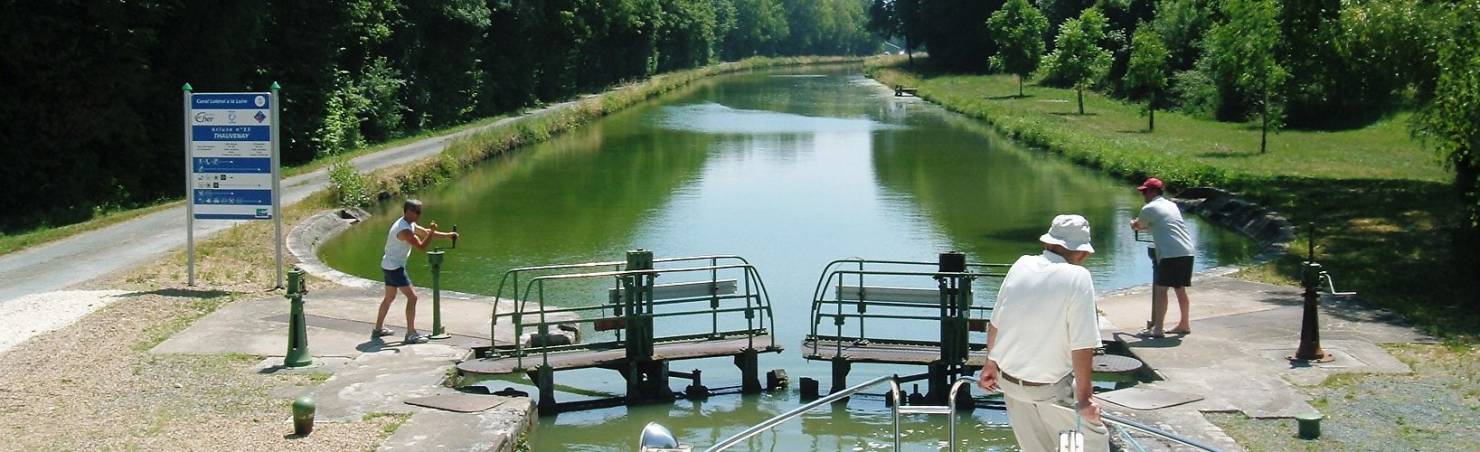 Two men operating manual canal lock gates on Canal Latéral à la Loire south of Sancerre.