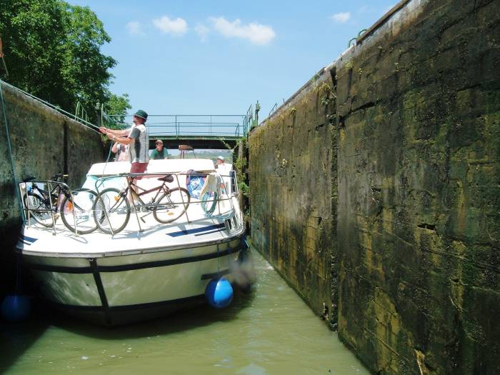 Taking a rented boat through a lock on a French canal.