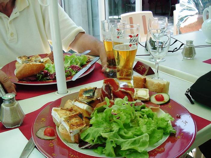 Food alongside the canal in central France: salad, garlic bread, wine, beer.
