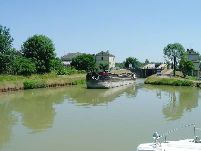 A commercial barge exits a lock on a French canal.