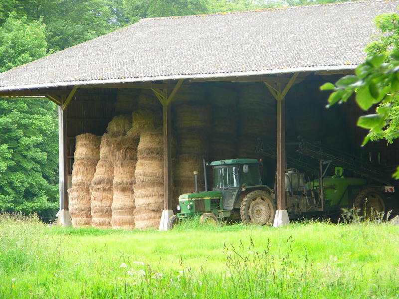 Barn, large hay bales, and tractor at Château de Bosmelet.