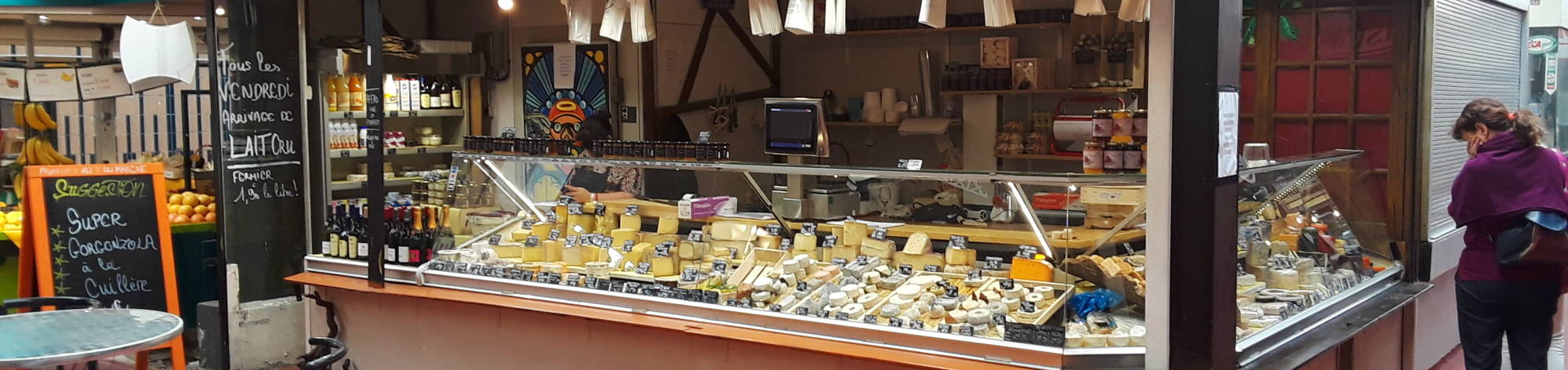 A Parisian shopper considers a wide array of cheese.