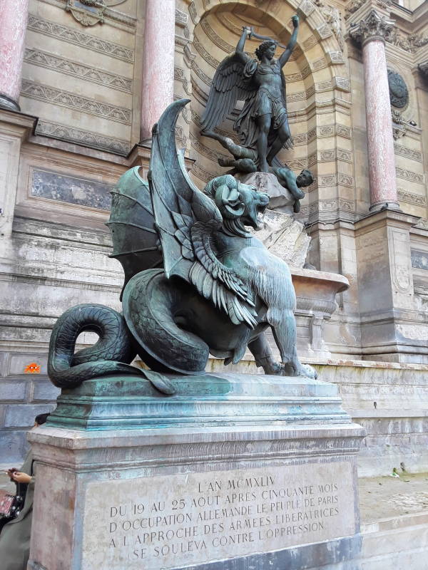 Dragon statues at the fountain at Place Saint-Michel near the Seine River through Paris.
